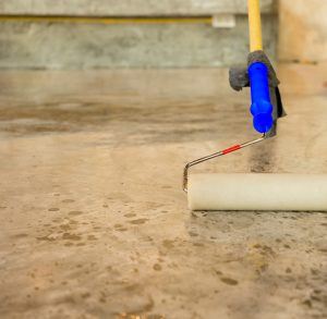 Work lacquering concrete floors using roller for coating